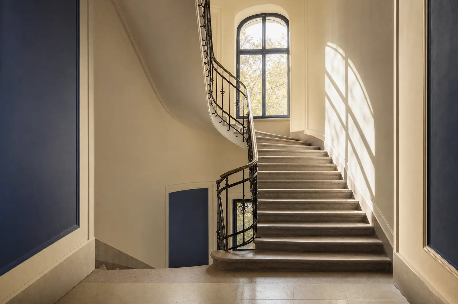 Lichtdurchflutetes Stiegenhaus mit Steinboden und filigranem Geländer – KI-generiertes Symbolbild